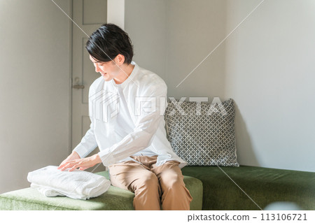 一個男人折疊洗衣浴巾/一個男人做家務 一個男人折疊洗衣浴巾/一個男人做家務 113106721