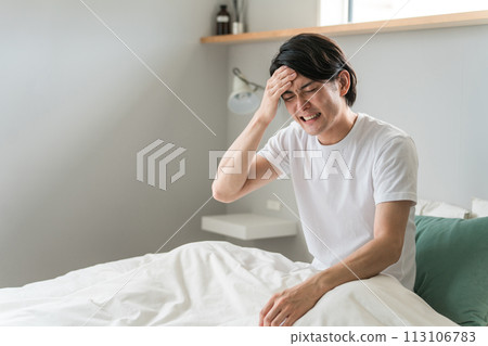 A man suffering from a headache and fever in bed (unwell, fever, lack of sleep, cold, corona) A man suffering from a headache and fever in bed (unwell, fever, lack of sleep, cold, corona) 113106783