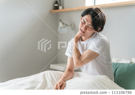 一名年輕的亞洲男子早上起床時患有肩膀僵硬(疲勞、睡眠困難、四十肩) 一名年輕的亞洲男子早上起床時患有肩膀僵硬(疲勞、睡眠困難、四十肩) 113106786