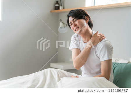 A young Asian man who suffers from stiff shoulders when he wakes up in the morning (fatigue, trouble sleeping, forty shoulders) A young Asian man who suffers from stiff shoulders when he wakes up in the morning (fatigue, trouble sleeping, forty shoulders) 113106787