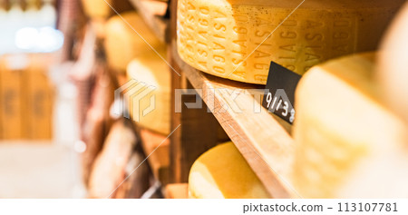 A cheese factory with rows of cheese holes [Image of a whole cheese] 113107781
