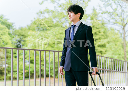 A businessman walking with a suitcase on a business trip, transfer, transfer, promotion, etc. A businessman walking with a suitcase on a business trip, transfer, transfer, promotion, etc. 113109029