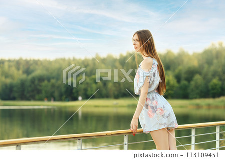 Young woman enjoying serene lake view 113109451