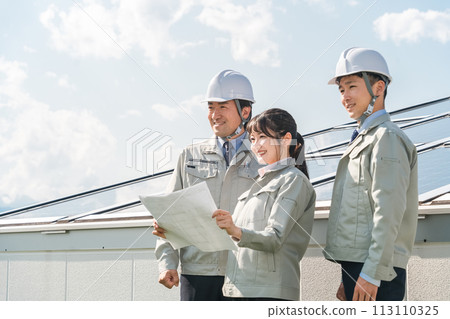 電力公司或電氣承包商穿著工作服的工程師站在太陽能發電/太陽能板(清潔能源)前 電力公司或電氣承包商穿著工作服的工程師站在太陽能發電/太陽能板(清潔能源)前 113110325