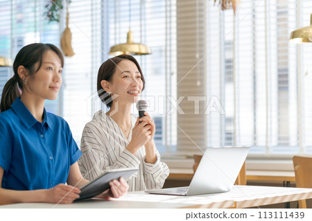 A woman holding a microphone and asking a question A woman holding a microphone and asking a question 113111439