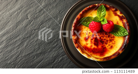 Delicious popular dessert creme brulee on a stone table with copy space for advertising, served with fresh berries and mint leaf, top view Delicious popular dessert creme brulee on a stone table with copy space for advertising, served with fresh berries and mint leaf, top view 113111489