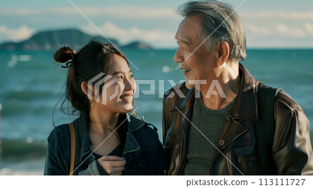 Portrait of a loving father and teenage daughter while walking by the sea on a sunny day, father's day poster concept 113111727