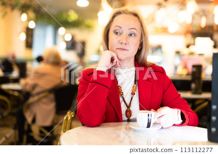 Portrait of stylishly dressed woman with cup of coffee in restaurant Portrait of stylishly dressed woman with cup of coffee in restaurant 113112277