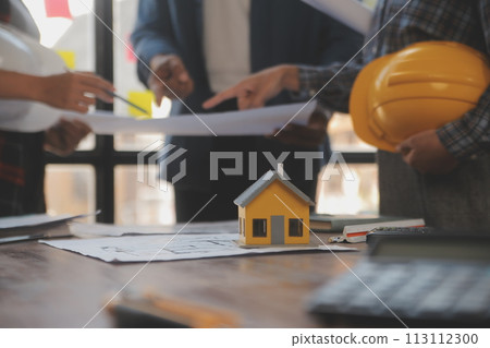 A team of construction engineers talks to managers and construction workers at the construction site. Quality inspection, work plan, home and industrial building design project A team of construction engineers talks to managers and construction workers at the construction site. Quality inspection, work plan, home and industrial building design project 113112300