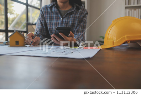 A team of construction engineers talks to managers and construction workers at the construction site. Quality inspection, work plan, home and industrial building design project 113112306