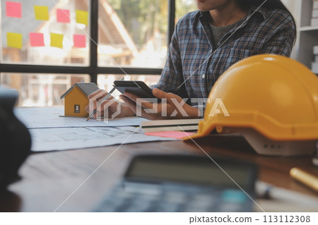 A team of construction engineers talks to managers and construction workers at the construction site. Quality inspection, work plan, home and industrial building design project 113112308