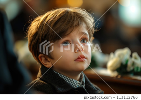A sad little Caucasian boy at a funeral ceremony in a church A sad little Caucasian boy at a funeral ceremony in a church 113112766