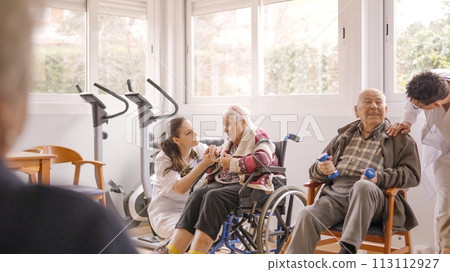 Physiotherapists talking to senior people while exercising in geriatrics Physiotherapists talking to senior people while exercising in geriatrics 113112927