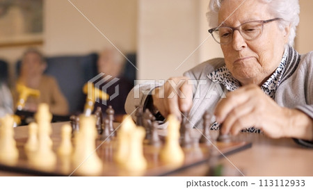 Two senior friends playing chess board game in geriatric Two senior friends playing chess board game in geriatric 113112933
