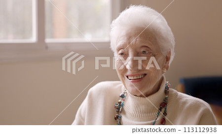 Old woman smiling at camera in a geriatric Old woman smiling at camera in a geriatric 113112938