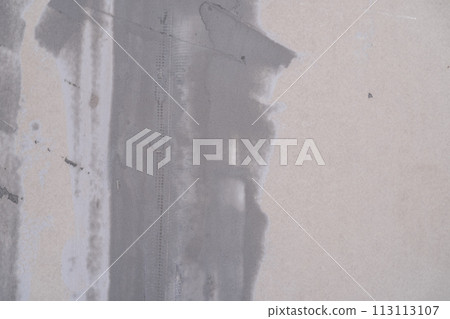 Applying decorative putty. White abstract texture of surface covered with putty. textured background of filler paste applied with putty knife in irregular dashes and strokes. Rough surface plaster 113113107