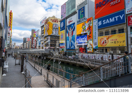遊客漫步在道頓堀或道頓堀夜間購物和街頭小吃，道頓堀是日本大阪心齋橋的著名旅遊景點。 113113896