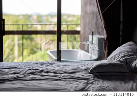 Empty bed in apartment bedroom 113114016