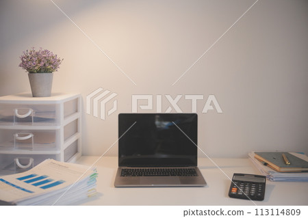 Laptop and paperwork on conference table Laptop and paperwork on conference table 113114809