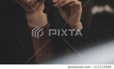 Young woman working in call centre, surrounded by colleagues 113114880
