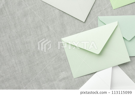 灰布背景和淺綠色和白色信封的俯視圖 113115099
