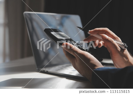 businessman working on desk office with using a calculator to calculate the numbers, finance accounting concept 113115815