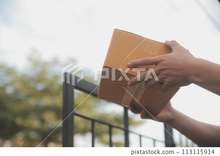 Asian delivery express courier young man use giving boxes to woman customer he wearing protective face mask at front home 113115914