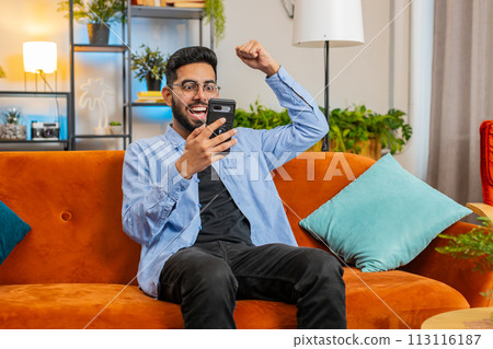 Surprised excited Indian man use smartphone reading good news amazed by online bet bid game win 113116187