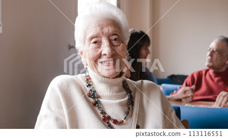 Portrait of smiling senior woman sitting in nursing home 113116551
