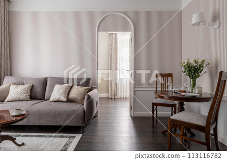 A buildings interior design with furniture like a couch, table, and chairs 113116782