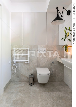 a bathroom with a toilet , sink and towel rack a bathroom with a toilet , sink and towel rack 113116828