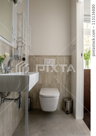 A bathroom with a toilet, sink, and mirror is a property fixture in a building 113116880