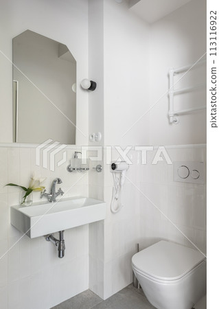 Bathroom with sink, toilet, and mirror in rectangular building interior design 113116922