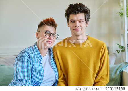 Portrait of happy middle-aged mother and son 19-20 years old hugging together 113117166