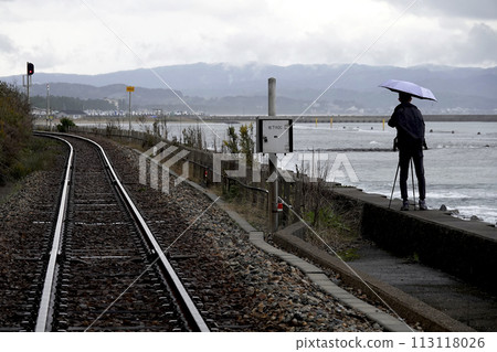Local railway tracks along the coastline and the silhouette of the photographer 113118026