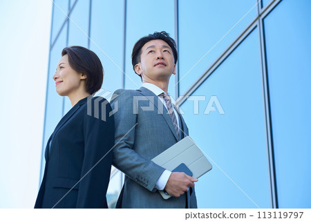 穿著西裝的男人與女人與現代建築 穿著西裝的男人與女人與現代建築 113119797