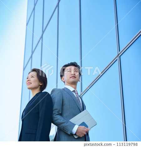 穿著西裝的男人與女人與現代建築 穿著西裝的男人與女人與現代建築 113119798