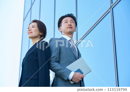 穿著西裝的男人與女人與現代建築 穿著西裝的男人與女人與現代建築 113119799