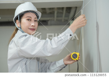 女工程師用捲尺測量長度 女工程師用捲尺測量長度 113120055