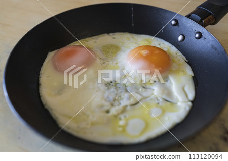 fried eggs close-up in a frying pan fried eggs close-up in a frying pan 113120094