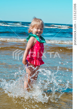 Girl of European appearance having fun in water on the beach and splashing Girl of European appearance having fun in water on the beach and splashing 113121006