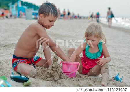 Brother and sister making sand castle on the beach Brother and sister making sand castle on the beach 113121037
