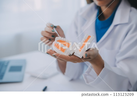 Dentists are discussing dental problems at report x-ray image on laptop screen to patients. Dentists are discussing dental problems at report x-ray image on laptop screen to patients. 113123209