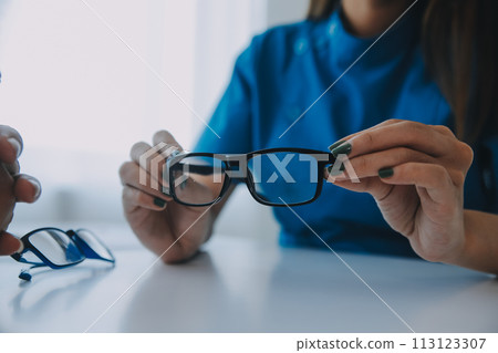 Close-up of Asian female doctor talking with elderly patient showing eyeball model and explaining eye disease in hospital Close-up of Asian female doctor talking with elderly patient showing eyeball model and explaining eye disease in hospital 113123307