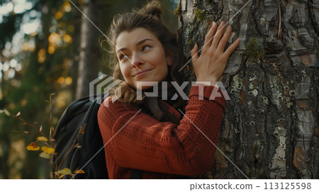 Caucasian woman hugging the trunk of a big tree in the forest. Caucasian woman hugging the trunk of a big tree in the forest. 113125598