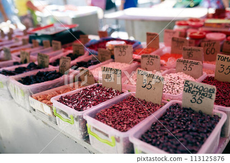 Different kinds of beans and dried fruits on sale at the local farmers summer market outdoors. Natural organic food on market place. Different kinds of beans and dried fruits on sale at the local farmers summer market outdoors. Natural organic food on market place. 113125876