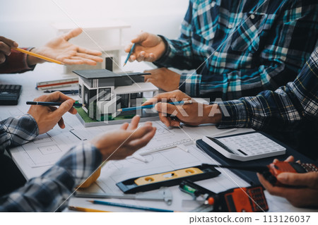 engineer people meeting working and pointing at a drawings in office for discussing. Engineering tools and construction concept. engineer people meeting working and pointing at a drawings in office for discussing. Engineering tools and construction concept. 113126037