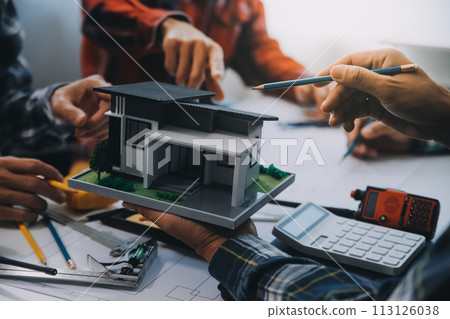 engineer people meeting working and pointing at a drawings in office for discussing. Engineering tools and construction concept. engineer people meeting working and pointing at a drawings in office for discussing. Engineering tools and construction concept. 113126038