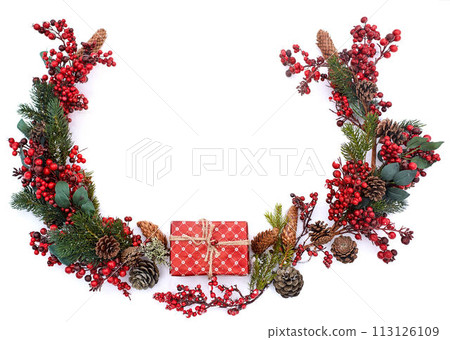 Christmas composition on isolated white background. New year wrapped gift, pine cones, thuja or fir branches and red berries on snow. Top view, flat lay, copy space. Circular shape. Decor for design. Christmas composition on isolated white background. New year wrapped gift, pine cones, thuja or fir branches and red berries on snow. Top view, flat lay, copy space. Circular shape. Decor for design. 113126109