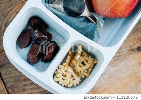 Dinner in a Muslim's lunchbox in an Asian country of onigiri, apple and soy sauce with a bottle of water Dinner in a Muslim's lunchbox in an Asian country of onigiri, apple and soy sauce with a bottle of water 113126579